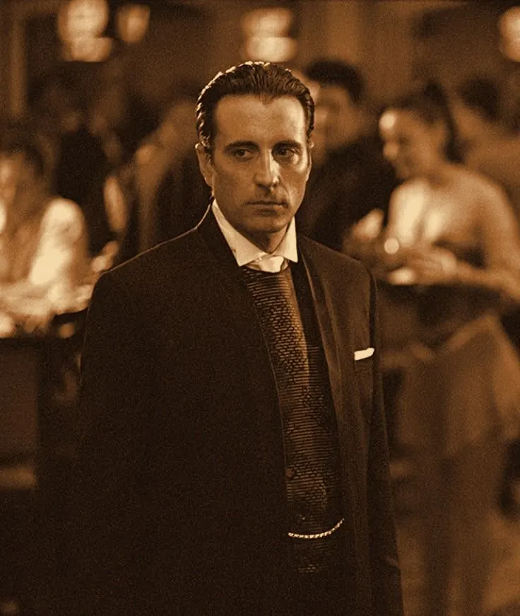 Terry Benedict in a black suit on his casino floor, tungsten tone