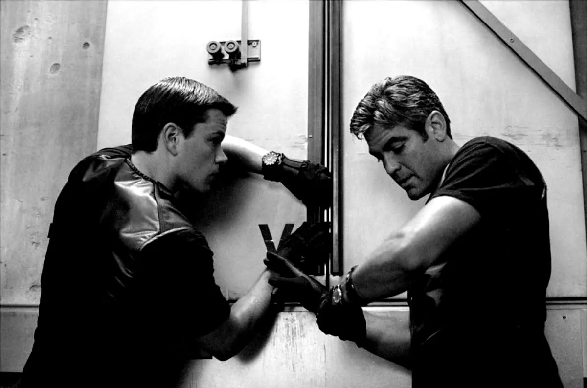 Two men in black working on a vault door