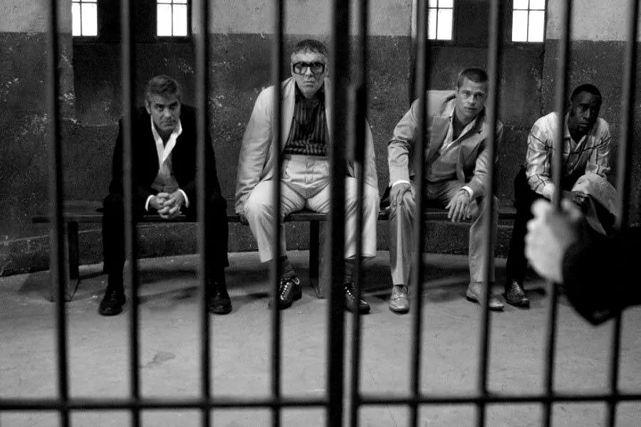 The crew sitting behind bars in a police cell