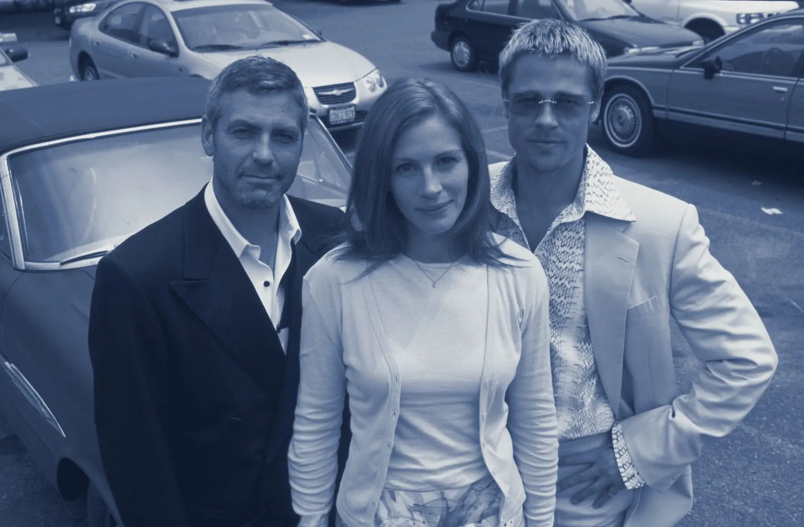 Danny, Tess and Rusty by parked cars on a European street, cyanotype tone